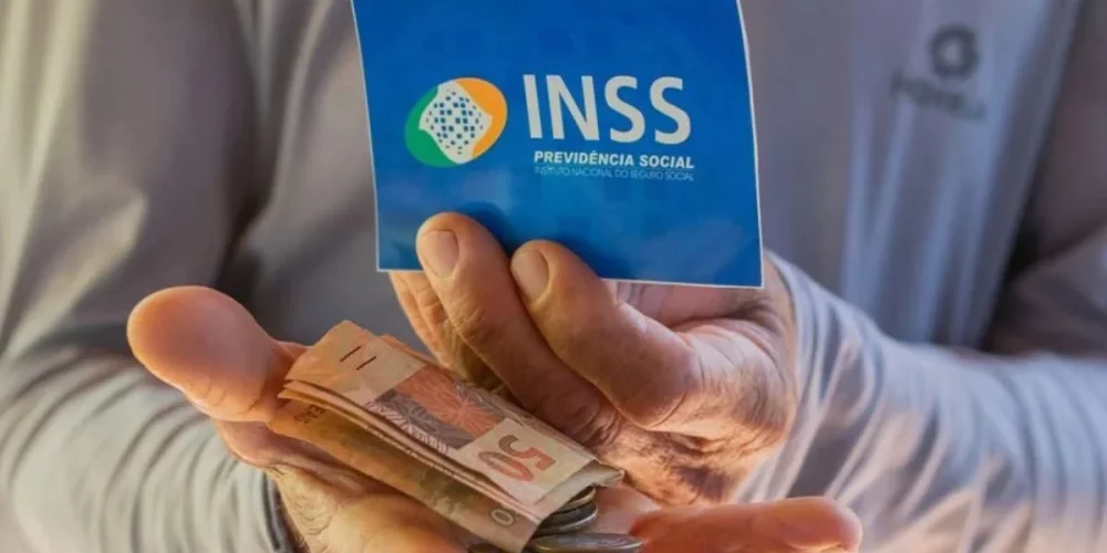 Beneficiario-do-INSS-segurando-cartao-e-notas-de-dinheiro