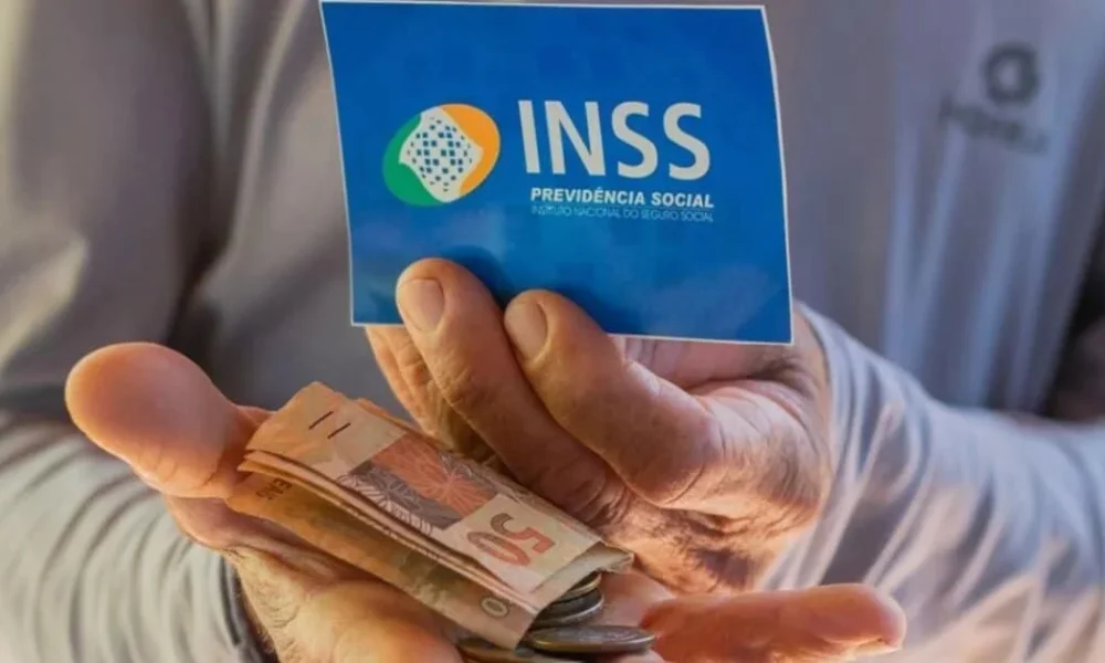 Beneficiario-do-INSS-segurando-cartao-e-notas-de-dinheiro